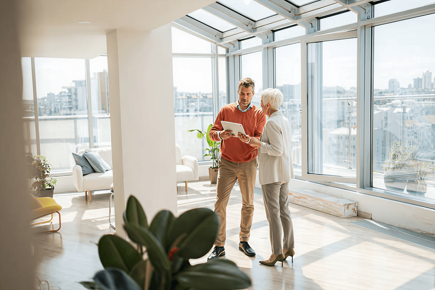 A Miland agent reviewing property details with a client beside a sunlit window