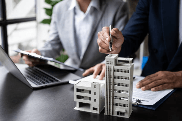Agent presenting a scale model of a building during a consultation